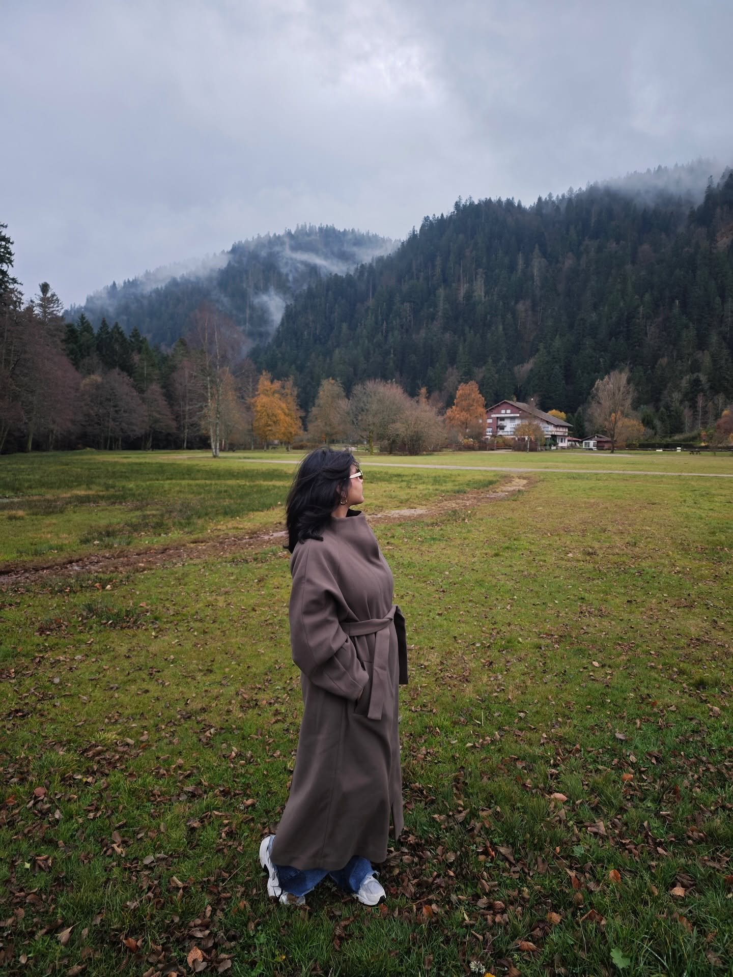 Maryam exploring a misty forest and mountain landscape