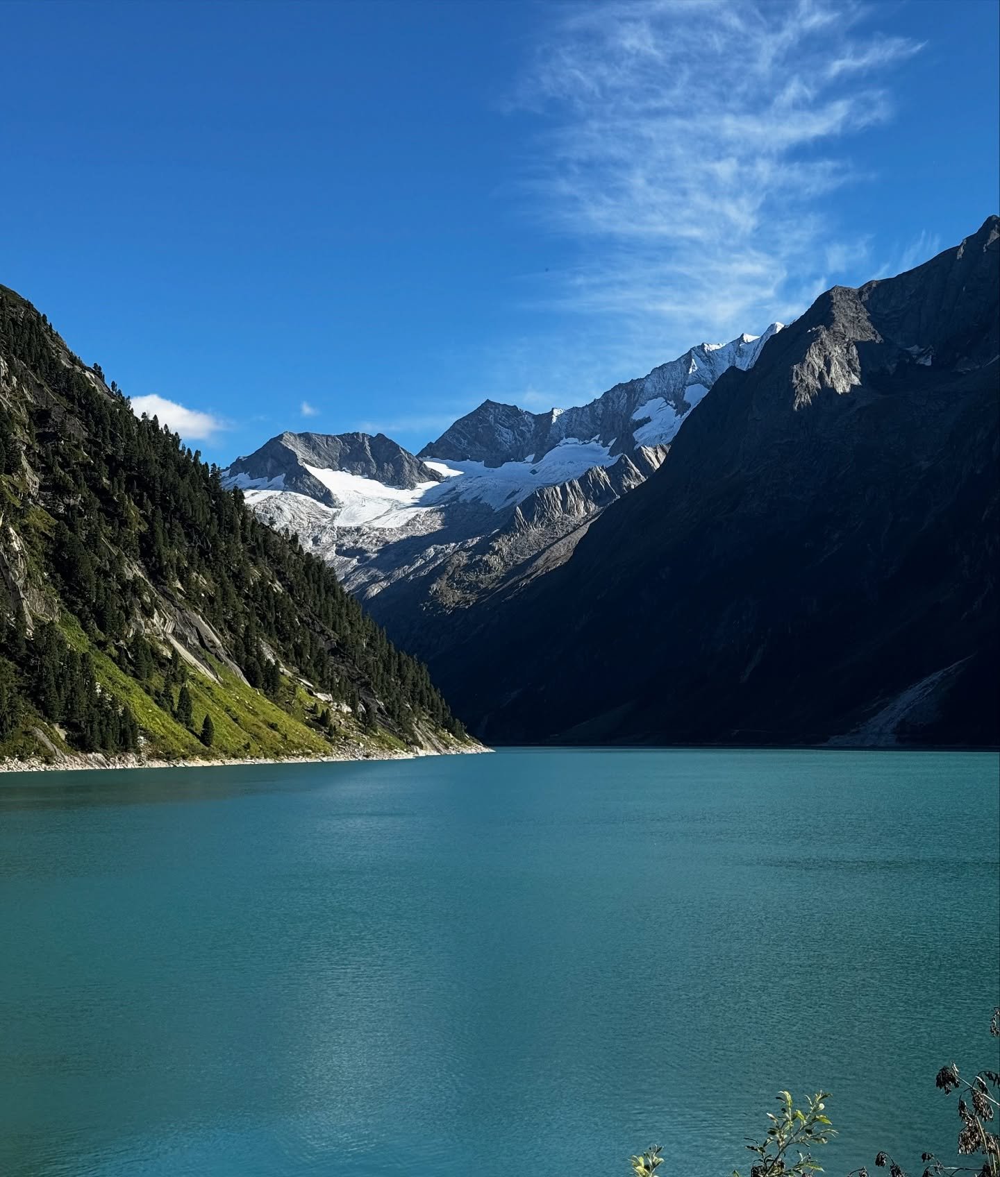 Turquoise alpine lake beneath snow-capped mountains